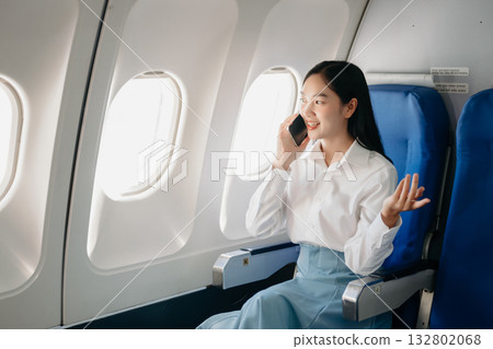 Young Asian executive excels in first class, multitasking with digital tablet, laptop and smartphone. Travel in style, work Young Asian executive excels in first class, multitasking with digital tablet, laptop and smartphone. Travel in style, work 132802068