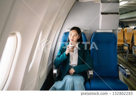 Photo of a frustrated woman sitting on an airplane with her head in her hands. Asian woman sitting in a seat 132802283