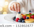 Child hand reaching  fruit on cake 132802877