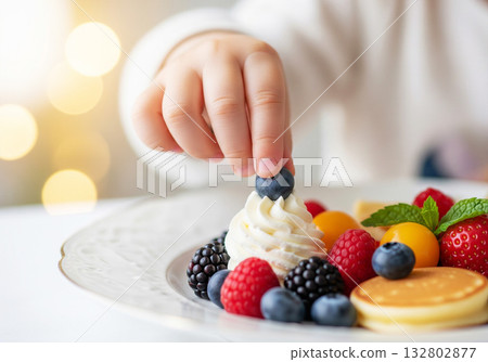 Child hand reaching fruit on cake Child hand reaching fruit on cake 132802877
