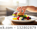 Child hand reaching food on plate 132802879