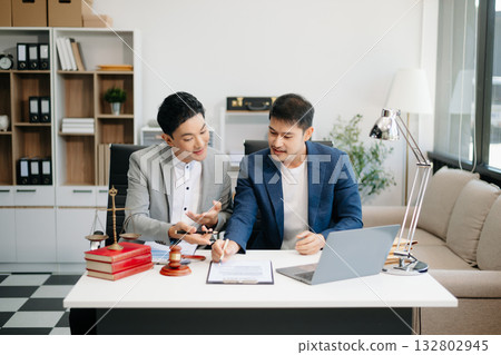 Asian business team and lawyers discussing contract papers sitting at the table. Concepts of law, advice, legal services. 132802945