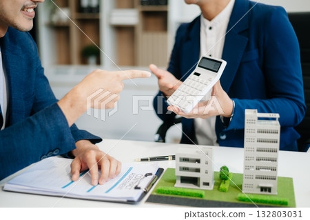 balancing the property sector The real estate agent is explaining the house style to see the house design and the purchase agreement. balancing the property sector The real estate agent is explaining the house style to see the house design and the purchase agreement. 132803031