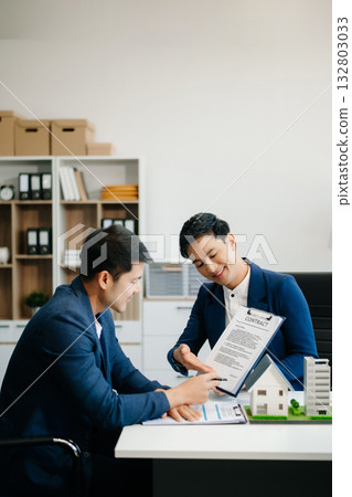 balancing the property sector The real estate agent is explaining the house style to see the house design and the purchase agreement. balancing the property sector The real estate agent is explaining the house style to see the house design and the purchase agreement. 132803033