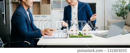 balancing the property sector The real estate agent is explaining the house style to see the house design and the purchase agreement. 132803035