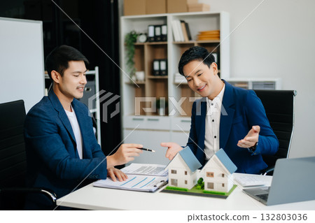 balancing the property sector The real estate agent is explaining the house style to see the house design and the purchase agreement. 132803036