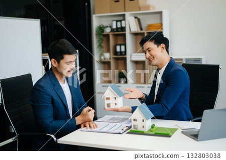 balancing the property sector The real estate agent is explaining the house style to see the house design and the purchase agreement. 132803038