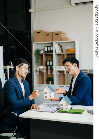 balancing the property sector The real estate agent is explaining the house style to see the house design and the purchase agreement. 132803039