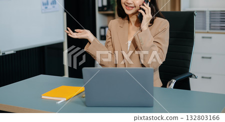 Young beautiful woman typing on tablet and laptop while sitting at the working white table 132803166
