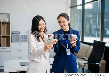 Two business worker standing and holding a coffee cup in modern office, successful, celebration, new project, team office concept 132803326