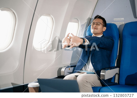 Photo of a frustrated man sitting on an airplane with her head in her hands. Asian Businessman sitting 132803727