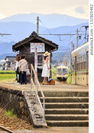 A woman waiting for a train on the platform of a rural station 132805462