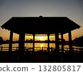 A gazebo illuminated by the setting sun over the lake 132805817