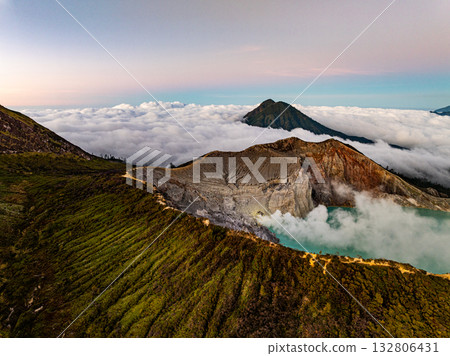 Aerial view of rock cliff at Kawah Ijen volcano with turquoise sulfur water lake at sunrise.Amazing nature landscape view at East Java, Indonesia.Natural landscape colorful sky background 132806431