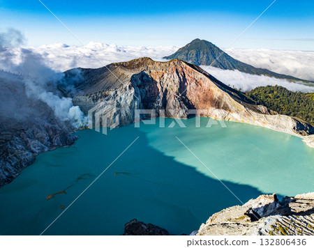 Aerial view of rock cliff at Kawah Ijen volcano with turquoise sulfur water lake at sunrise.Amazing nature landscape view at East Java, Indonesia.Natural landscape colorful sky background Aerial view of rock cliff at Kawah Ijen volcano with turquoise sulfur water lake at sunrise.Amazing nature landscape view at East Java, Indonesia.Natural landscape colorful sky background 132806436