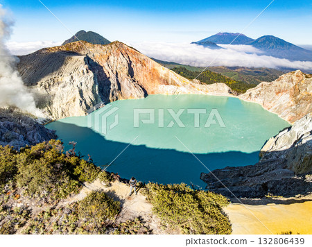 Aerial view of rock cliff at Kawah Ijen volcano with turquoise sulfur water lake at sunrise.Amazing nature landscape view at East Java, Indonesia.Natural landscape colorful sky background Aerial view of rock cliff at Kawah Ijen volcano with turquoise sulfur water lake at sunrise.Amazing nature landscape view at East Java, Indonesia.Natural landscape colorful sky background 132806439