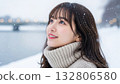 A woman in a turtleneck knit looking up at the snowy sky 132806580