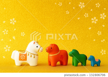 Colorful horse figurines lined up against a golden background - ideal for the zodiac, New Year, and other auspicious occasions 132806706