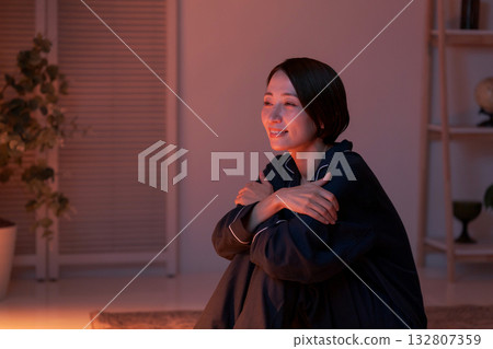 Woman sitting in pajamas Woman sitting in pajamas 132807359
