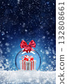 Christmas card with a toy ball and a gift inside on the snow. Festive banner with hoarfrost on night abstract defocused lights background. 132808661