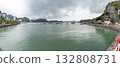 A panoramic view of the coastal landscape in Vietnam with boats on the water and mountains in the background, under a cloudy sky. 132808731