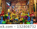 A vibrantly decorated altar in a Vietnamese temple, filled with offerings of flowers, fruits, and religious items.  132808732