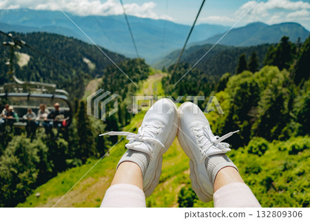 woman feet in sneakers in front of mountain view. cable road 132809306