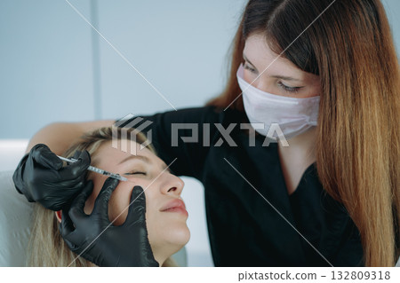 an aesthetic professional performing an injection procedure. Beauty treatment an aesthetic professional performing an injection procedure. Beauty treatment 132809318
