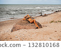 A serene beach scene with an individual relaxing on a rock, embracing the stunning beauty of nature 132810168
