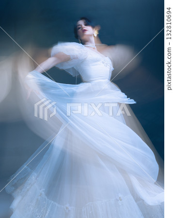 Expressive dancer in white gown, arms lifting fabric in cinematic blur 132810694