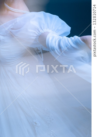 Close view of dancer sleeve in soft blur, delicate arm movement in light. Close view of dancer sleeve in soft blur, delicate arm movement in light. 132810714
