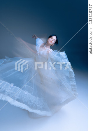 Wide twirl in embellished gown, poised arm line and airy motion blur Wide twirl in embellished gown, poised arm line and airy motion blur 132810737