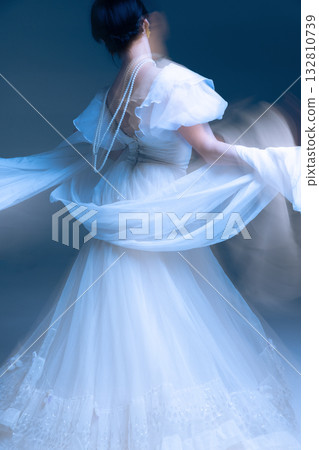 Dramatic skirt lift in white couture, expressive motion blur and sculptural gesture 132810739