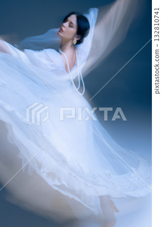 Flowing white dress in mid-spin, cinematic motion blur and elegant side profile Flowing white dress in mid-spin, cinematic motion blur and elegant side profile 132810741