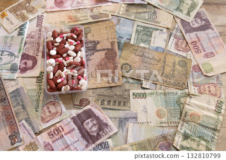 pills and capsules in plastic container on international currency pills and capsules in plastic container on international currency 132810799