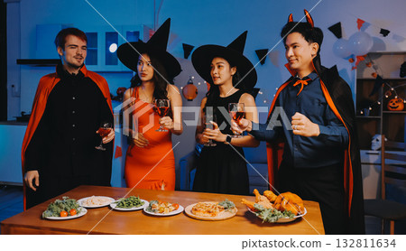 Joyful office Halloween party with coworkers in costumes, celebrating with drinks and laughter, fostering teamwork and festive spirit Joyful office Halloween party with coworkers in costumes, celebrating with drinks and laughter, fostering teamwork and festive spirit 132811634