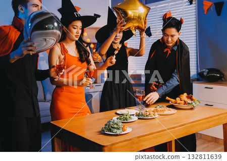 Joyful office Halloween party with coworkers in costumes, celebrating with drinks and laughter, fostering teamwork and festive spirit Joyful office Halloween party with coworkers in costumes, celebrating with drinks and laughter, fostering teamwork and festive spirit 132811639