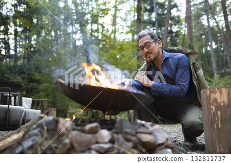 A man bonfire at a campsite A man bonfire at a campsite 132811737