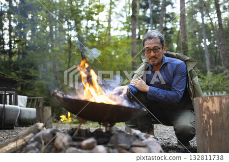A man bonfire at a campsite 132811738