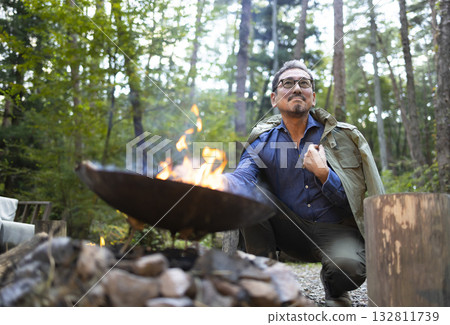 A man bonfire at a campsite A man bonfire at a campsite 132811739