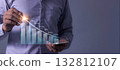 Young man with smartphone hand touching to visualize money growth The phone screen displays graphs  132812107
