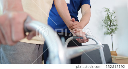 Caregiver assisting elderly patient with walker for mobility 132812192