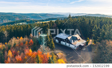Experience the stunning autumn colors surrounding Slovanka Lookout Tower, a historic iron structure nestled in the Jizera Mountains. Enjoy scenic views and serene forest landscapes. 132812199