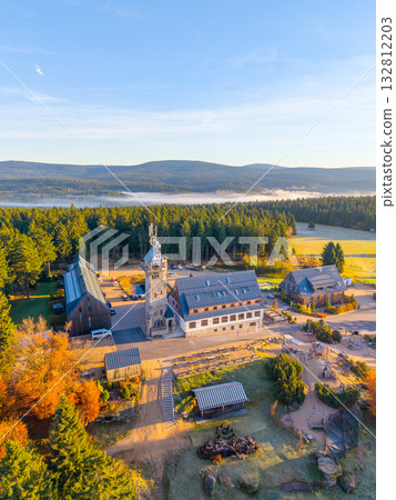 Visitors can enjoy stunning views from Kralovka Lookout Tower in the Jizera Mountains during the vibrant autumn season. The surrounding landscape showcases colorful foliage and serene hills. 132812203