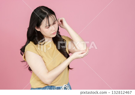 Health Awareness. Young woman examining her arm for discomfort. 132812467