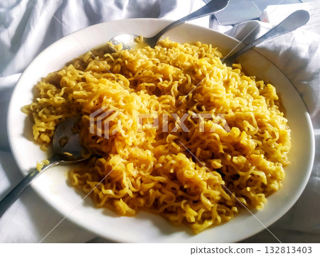 Cooked Instant Noodles in a white plate with Spoons Cooked Instant Noodles in a white plate with Spoons 132813403