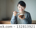 A young woman is eating and smiling. Image of a healthy diet and a happy breakfast 132813921