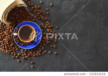 Close-up and top view of hot black coffee in blue coffee cup and roasted Thai coffee beans on wooden 132814228