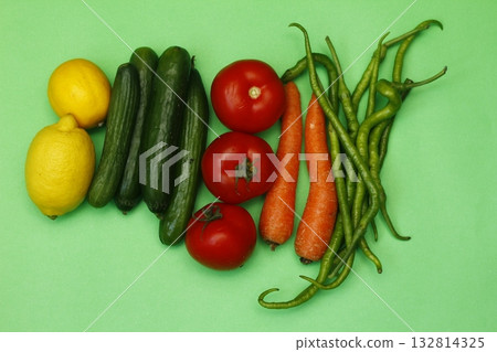 fresh vegetables isolated on green background. Lemon, tomato, pepper, cucumber and carrot. 132814325