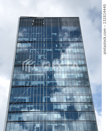 Futuristic skyscraper rising. Modern corporate tower with glass windows and reflective facade, 132814440